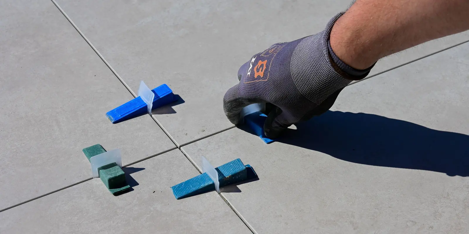 Pose de joints de carrelage avec croisillons sur un chantier