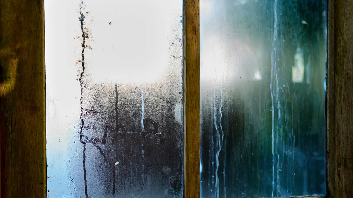 Condensation sur une fenêtre ancienne en bois